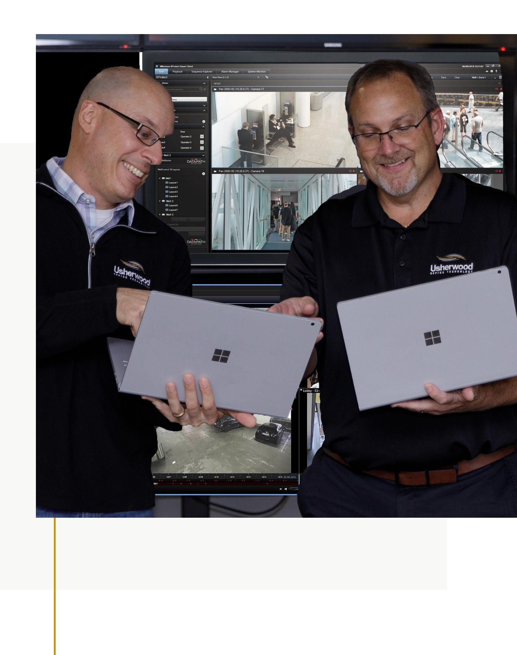 Employees meeting with laptops behind digital signage