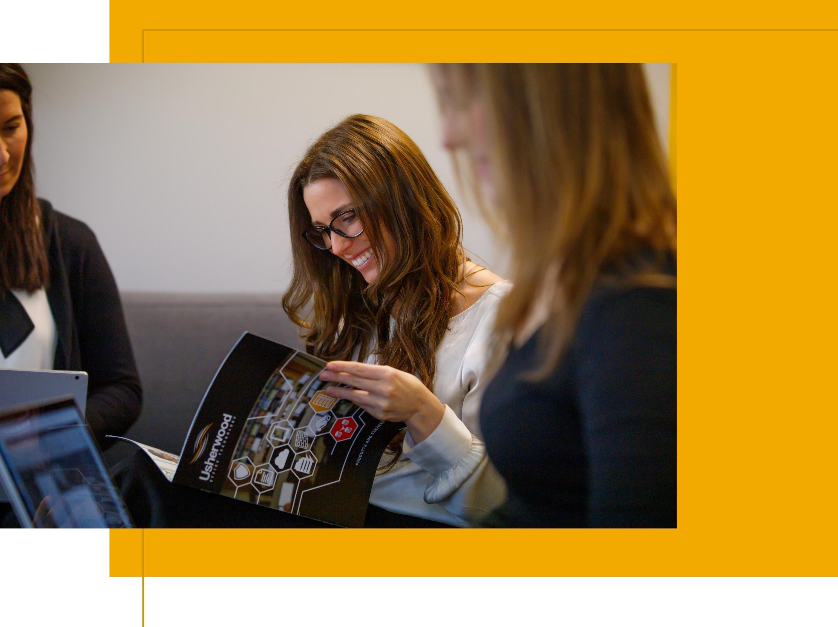 Women meeting and looking over Usherwood brochure