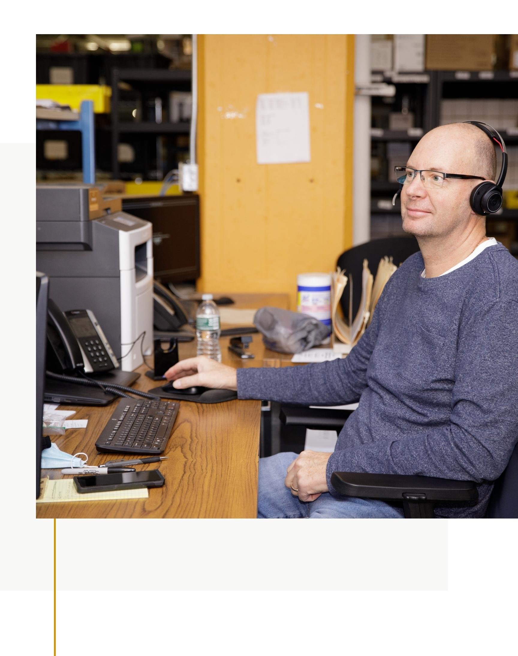 Usherwood employee with headset working at desk