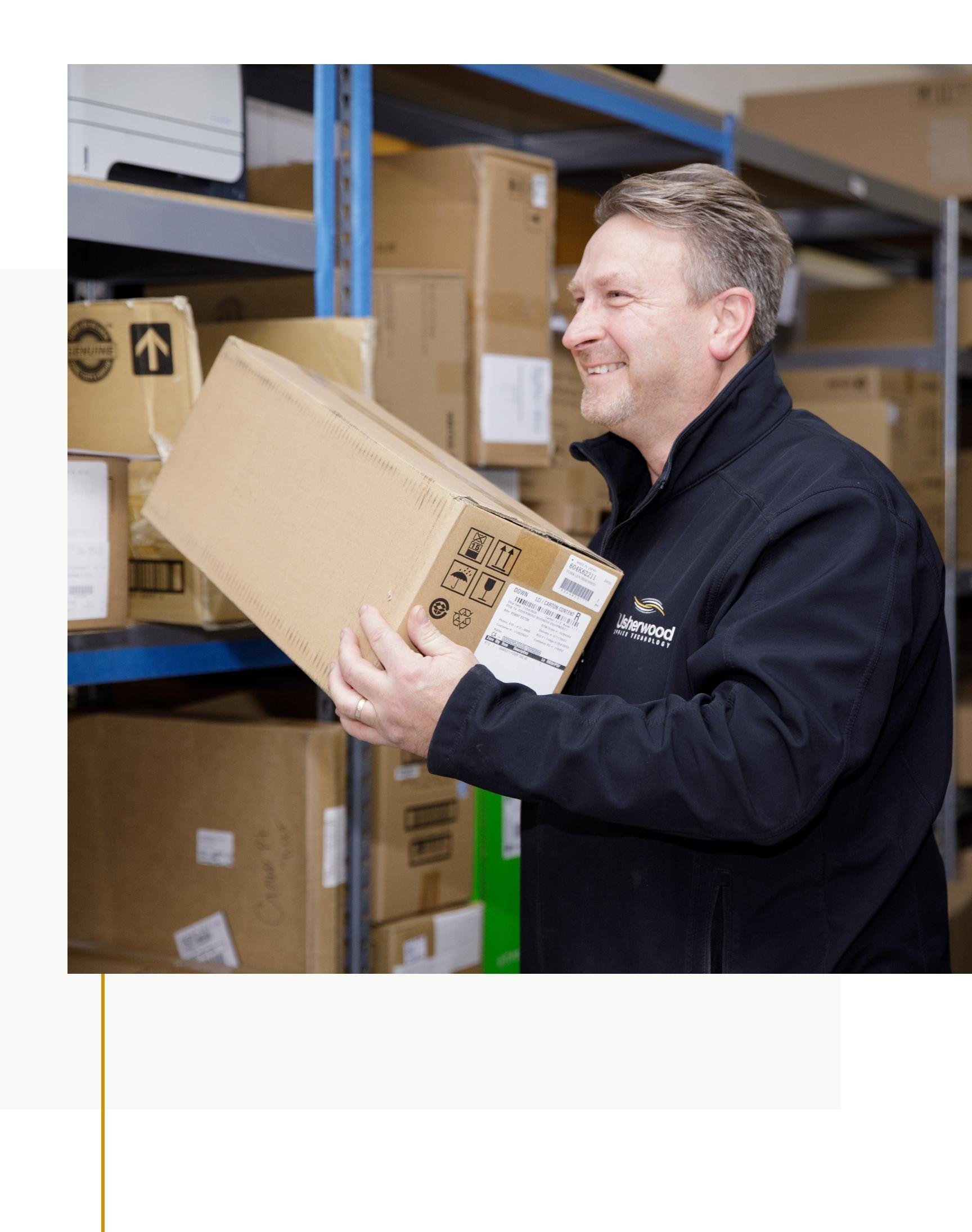Usherwood employee in warehouse taking a box from shelf