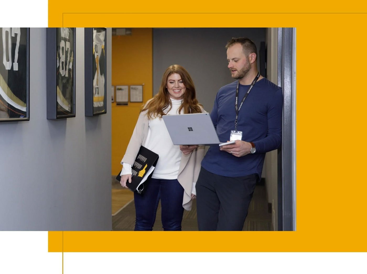 Usherwood employees in hallway discussing managed IT services