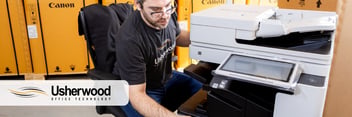 man looking at a secure printer with usherwood logo on the top left corner 