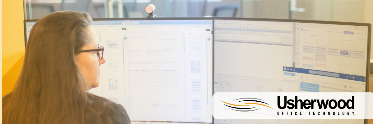 Women looking at schedule at computer representing cloud communications with usherwood logo in the back