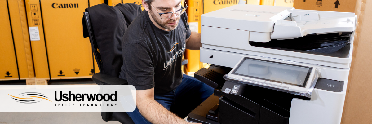 man looking at a secure printer with usherwood logo on the top left corner 